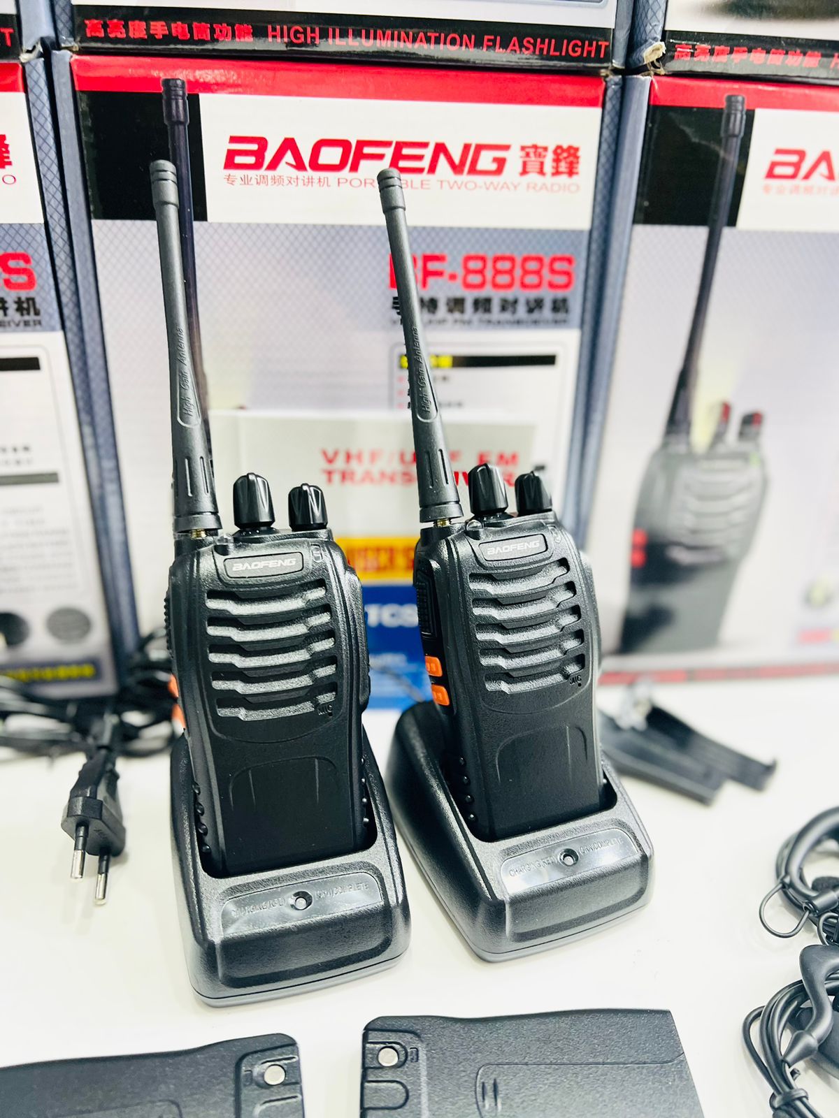 Two walkie-talkies with a Baofeng branded box in the background.