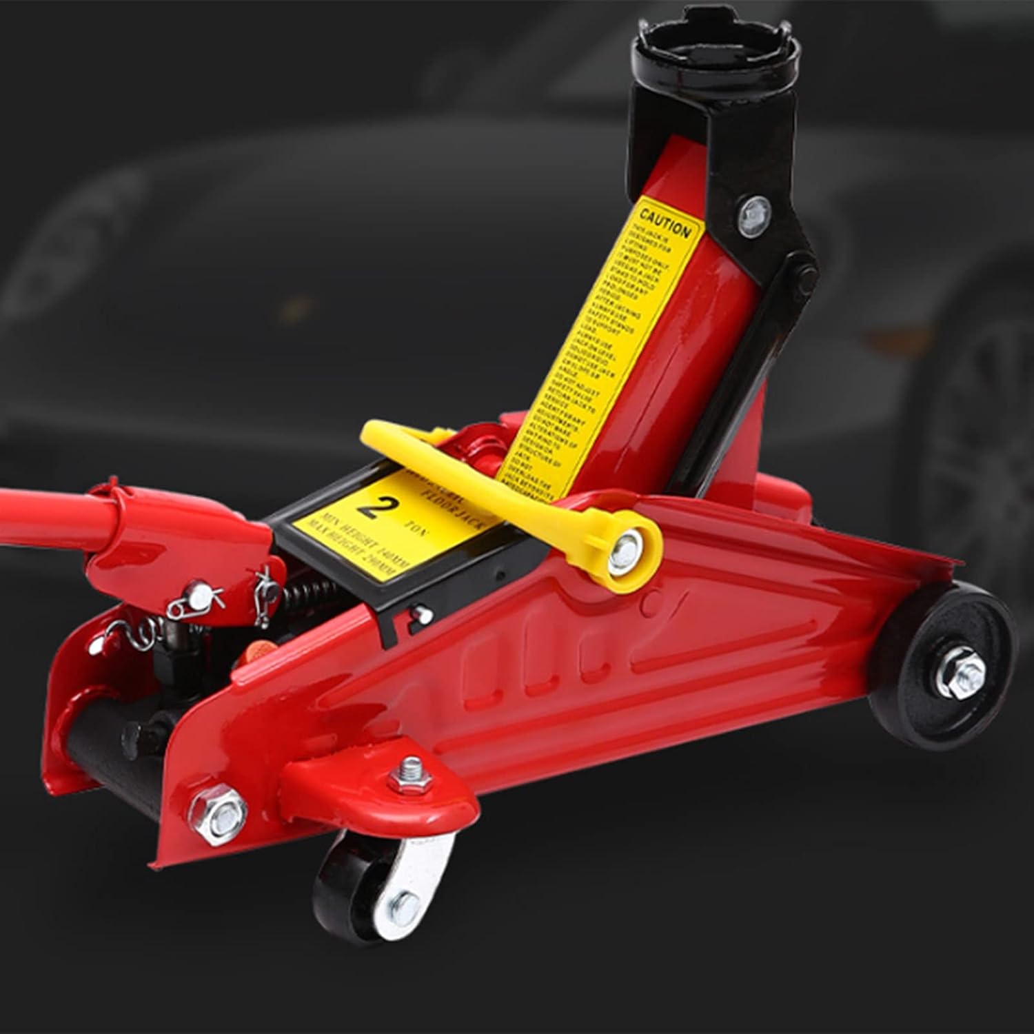 Red car jack with yellow label on a dark background